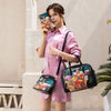 Woman wearing a pink silk dress styled with the Nicole Lee AKIKO LA BELLEZA 3 PIECE SET (Handbag, Crossbody, Wallet) featuring a 3-in-1 design featuring a large zip handbag with dual handles, a zip crossbody bag, and a zip wallet in a Japanese-inspired exclusive fashion print of a woman named Akiko making music against a snowy mountain with a lucky cat.