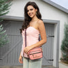 WOMEN IN A PINK SLEEVELESS TOP AND BLUE JEANS SHORTS WEARING OUR MARGOT 2 PIECE CROSSBODY IN PINK SET IN A MODERN BACKGROUND.