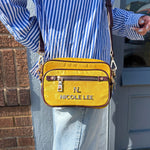 WOMEN IN A BLUE STRIP BLOUSE AND BLUE JEANS WEARING ACROSS OUR NICOLE LEE MARGOT 2 PIECE CROSSBODY IN YELLOW.