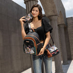 Introducing the latest addition to our beloved signature 3-piece sets: the Family Yearbook 3-in-1 set! Featuring a large backpack, crossbody, and wallet, this set combines style and practicality with a playful design that’s perfect for any occasion. Vegan leather travel set with a fun and cute fashion print of dogs and cats stylishly dressed to the nines with a city scape line drawing background and flower details. Model wearing all three items styled together against a modern background outside. 
