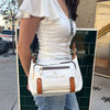 WOMEN IN A WHITE TOP AND BLUE JEANS USING OUR MARGOT SHOULDER BAG IN WHITE.