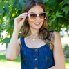 woman in denim smiling while holding our NL square sunglasses.