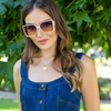 woman in denim dress stylishly posing with our white square sunglasses set on a greenery background.
