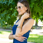 woman in denim dress smiling while  NL Square sunglasses in white.