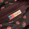 Interior lining of Nicole Lee Laides Night Out handbag part of the Nicole Lee 3-in-1 Ladies Night Out handbag set. Interior with maroon red accents, a Nicole Lee logo nameplate and Nicole Lee exclusive premium print interior lining with polka dot design in brown and pink colorway. 
