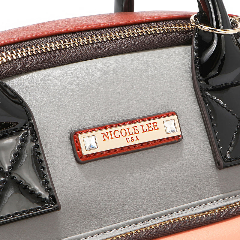 Front close-up shot of the vegan leather and glossy patent leather accents of the Violet Blossoms backpack, part of the 3-in-1 travel-friendly Violet Blossoms set (backpack, crossbody, wallet). Gold-tone logo engraved nameplate with diamond rhinestones. 