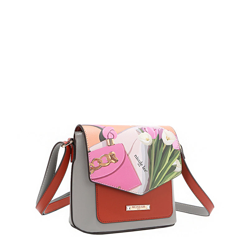 Front angle of the Nicole Lee vegan leather Violet Blossoms flap crossbody, part of the VIOLET BLOSSOM 3 PIECE SET (Backpack, Crossbody, Wallet). Illustration of pink and white tulips against a Nicole Lee branded dust bag and hot pink structured chain link bag. Adjustable shoulder strap and logo-engraved gold-tone nameplate with diamond rhinestones. 