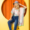 woman wearing our printed kimono and blue jeans and our printed hat set on a orange background.