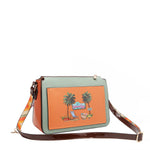 Our Sun and Sand Crossbody bag with palm tree design on an orange background with straps