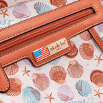 Close-up of our  'nicole lee' label on a shell-patterned background