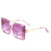OUR PURPLE OVERSIZED STUDDED SUNGLASSES. STUD DETAILING AND NICOLE LEE RHINESTONE LOGO ON THE SIDES OF THE FRAMES.