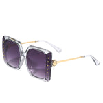 OUR SMOKE GRAY OVERSIZED STUDDED SUNGLASSES. STUD DETAILING AND NICOLE LEE RHINESTONE LOGO ON THE SIDES OF THE FRAMES.