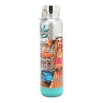THE TUMBLER HAS A CYLINDRICAL SHAPE WITH A SCREW CAP, IN MARTHA TRAVELS ITALY PRINT. IT HAS A SILVER GLITTER BACKGROUND. THE FRONT HAS THE IMAGE OF A BLONDE GIRL TOUCHING HER HAT AND HOLDING A CUP WITH A HANDBAG ON HER ARM. AT THE BOTTOM IS A BLUETOOTH SPEAKER COLOR MINT.
